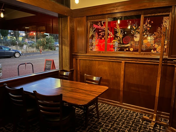 Interior of Cassidy's Restaurant and Bar with wooden furnishings, decorative Asian-inspired window displays, and street… — Goose Hollow, Portland