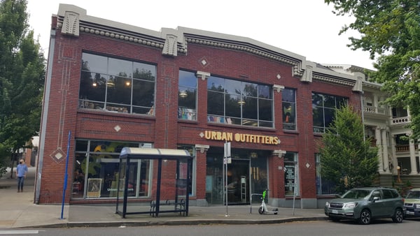 Urban Outfitters storefront in a red brick building with large windows on a city street. — Northwest District, Portland