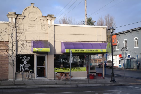 Po'shines Café storefront with purple awning on a Portland street corner, featuring pulled pork and chicken offerings.