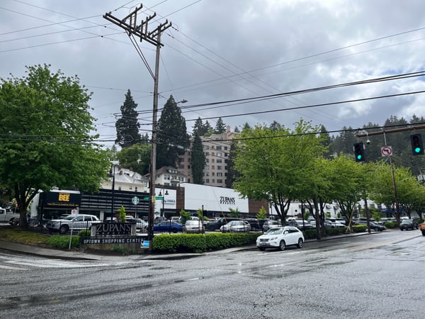 Zupan's Uptown Shopping Center storefront with parking lot, residential buildings, and tree-lined street in Portland. — Goose Hollow, Portland
