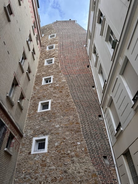 Historic brick tower with white-framed windows viewed from a narrow Parisian alleyway, flanked by modern residential… — 11th Arrondissement, Paris